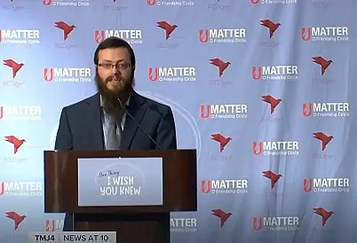 Man at podium with 'I WISH YOU KNEW' and 'U MATTER' on TMJ4 News