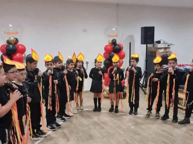 ילדים לבושים בשחור עם כובעי להבה אוחזים מיקרופונים במופע