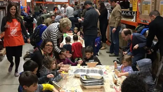 Parents and children gather around a table to make menorahs for the Jewish holiday of Hanukkah in Deerfield. (Steve Sadin/Pioneer Press)