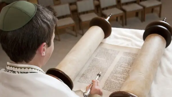 A young man reads the Torah.