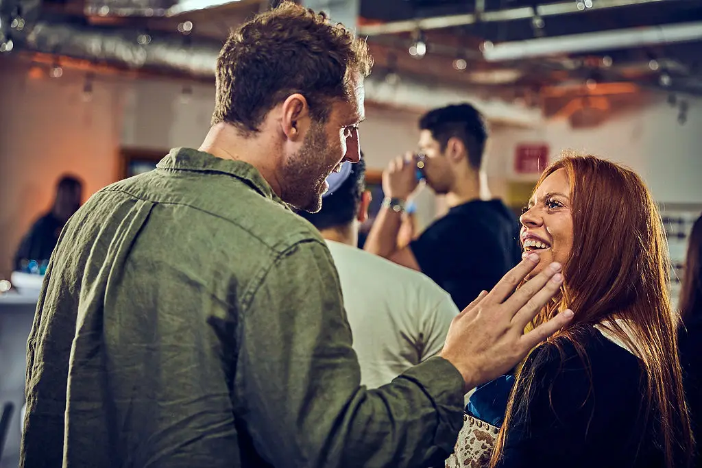 A man and woman laughing together mid-conversation at a CYP DoBo evening event.