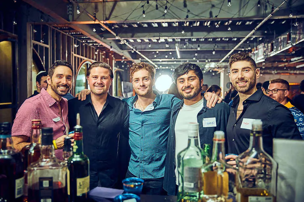 Five friends arm in arm, smiling together at a CYP DoBo evening event.