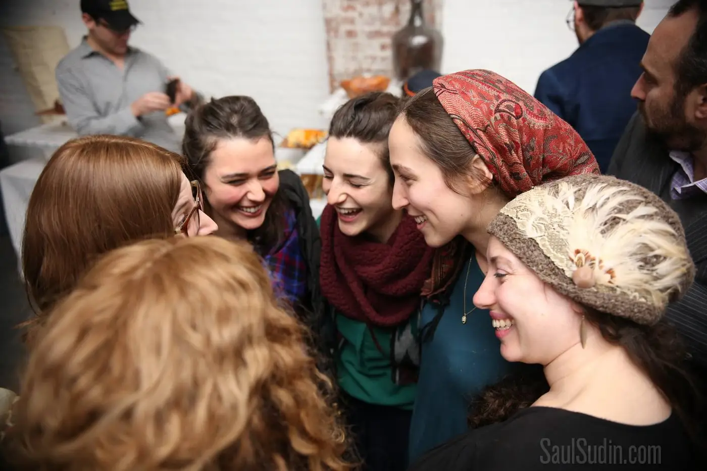 Group of friends smiling and laughing together at a social gathering.