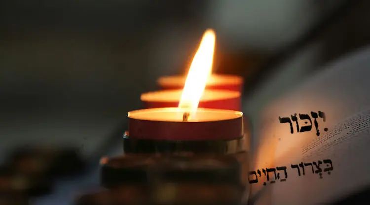 Memorial candle beside an open prayer book